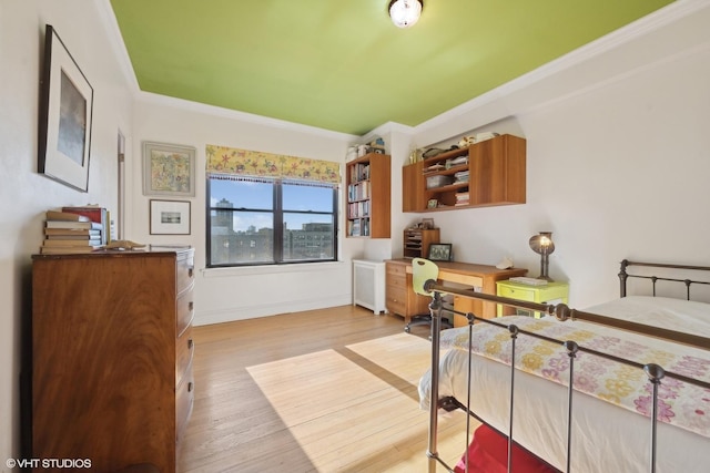 bedroom with light hardwood / wood-style flooring and ornamental molding