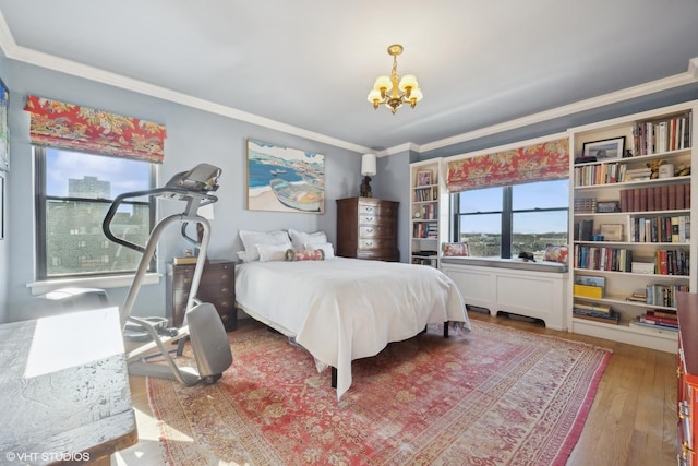 bedroom featuring wood-type flooring, ornamental molding, and a chandelier