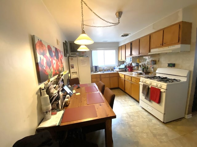 kitchen with white appliances, hanging light fixtures, and sink