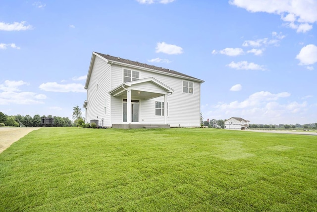 back of property with central AC unit and a yard