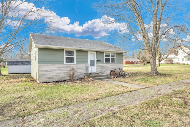 view of front of property featuring a shed and a front lawn