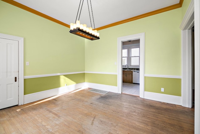 spare room featuring crown molding and light hardwood / wood-style flooring