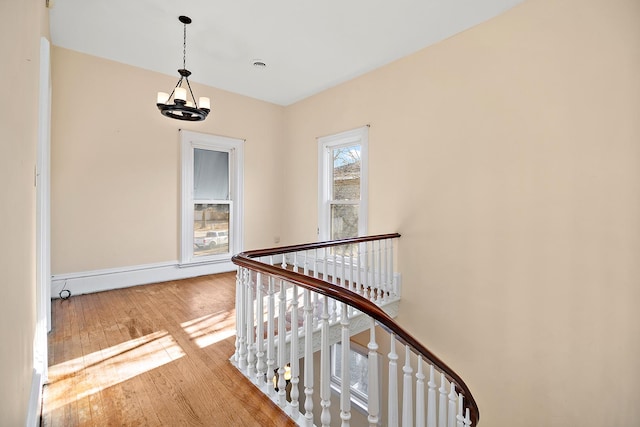 hallway featuring light wood-type flooring and a chandelier