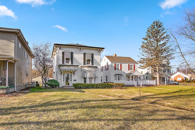 rear view of house featuring a lawn and central AC unit