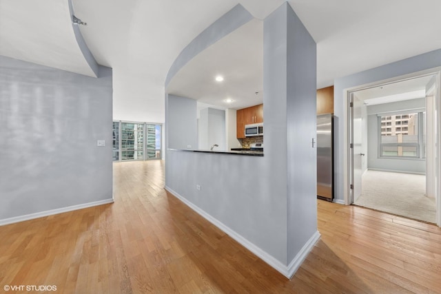 hallway with light hardwood / wood-style floors