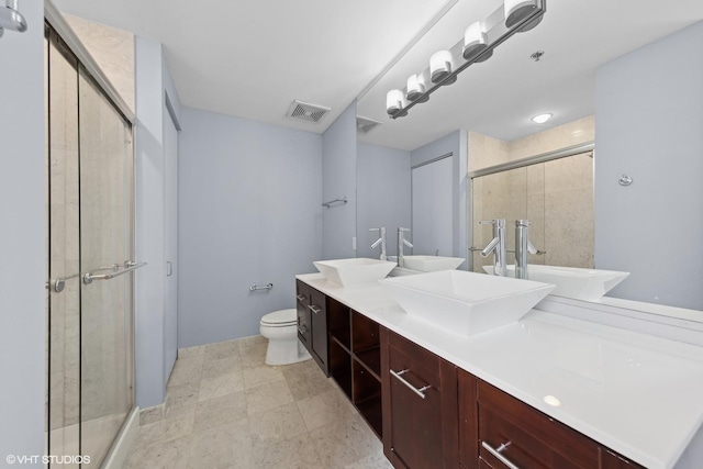 bathroom featuring vanity, toilet, and a shower with shower door