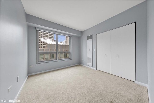 unfurnished bedroom featuring light colored carpet and a closet