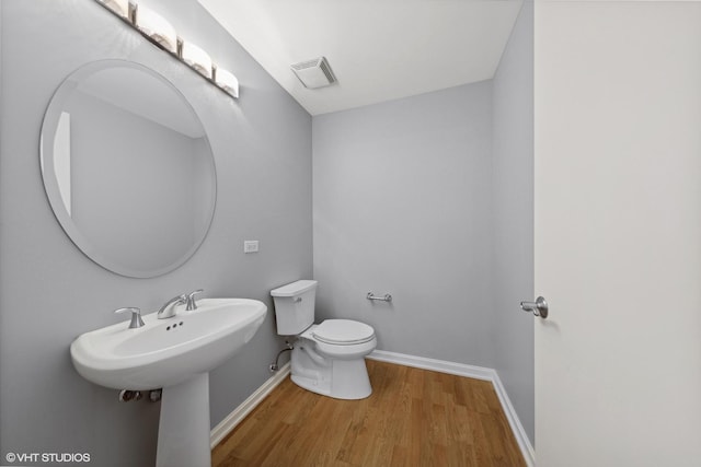 bathroom with hardwood / wood-style floors, toilet, and sink