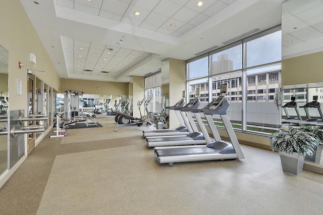 gym with a drop ceiling and a high ceiling