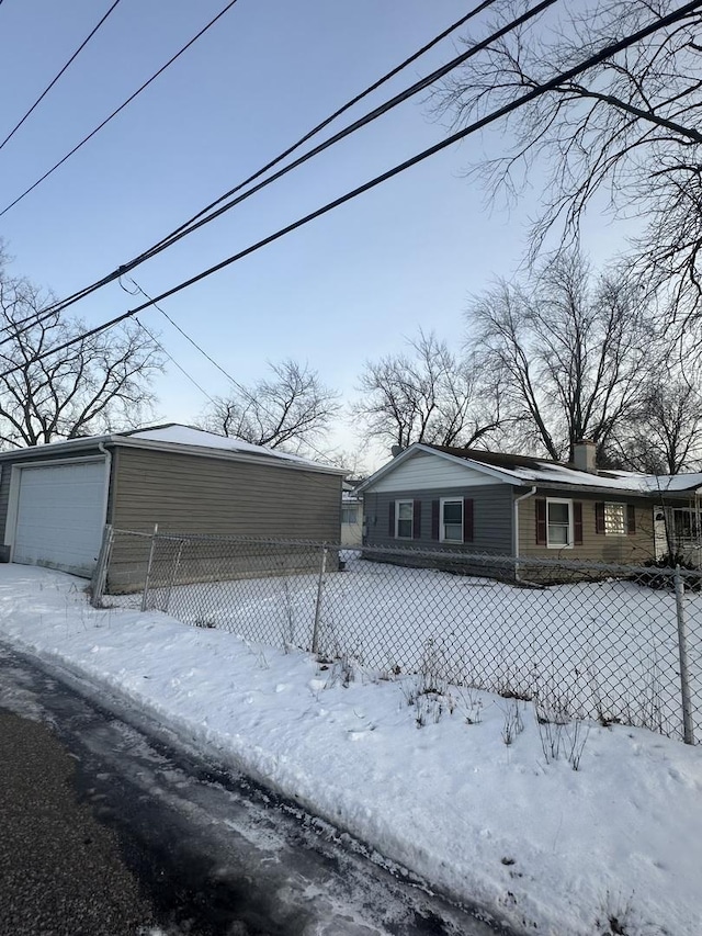 exterior space featuring a detached garage and fence