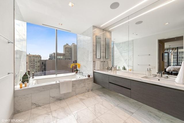 bathroom with tiled tub and vanity