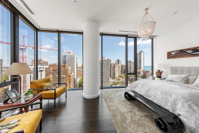 bedroom featuring multiple windows, dark hardwood / wood-style flooring, expansive windows, and a notable chandelier