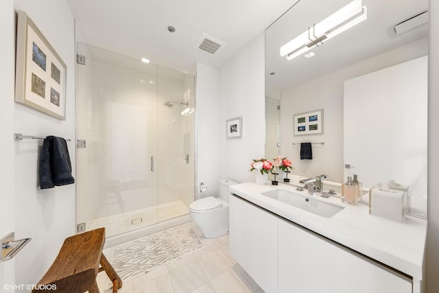 bathroom with tile patterned floors, a shower with door, vanity, and toilet