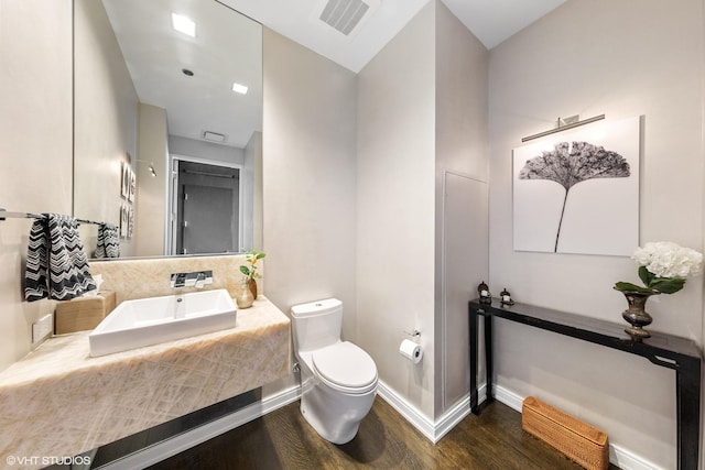 bathroom featuring hardwood / wood-style floors, toilet, and sink