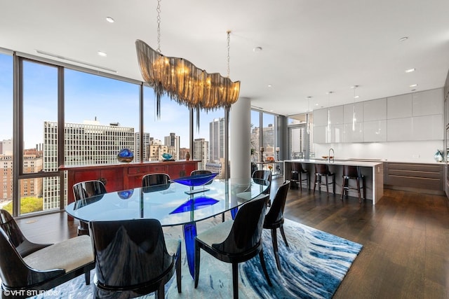 dining area with a notable chandelier, expansive windows, and dark hardwood / wood-style floors