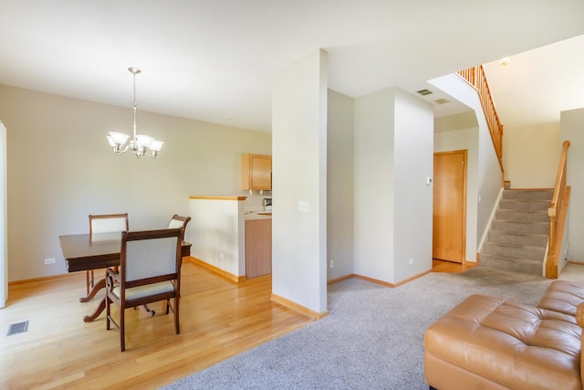 dining room with light colored carpet and an inviting chandelier