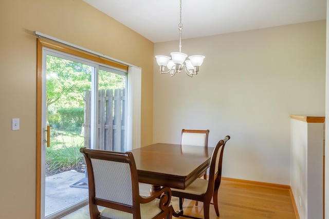 dining area with light hardwood / wood-style flooring and a chandelier