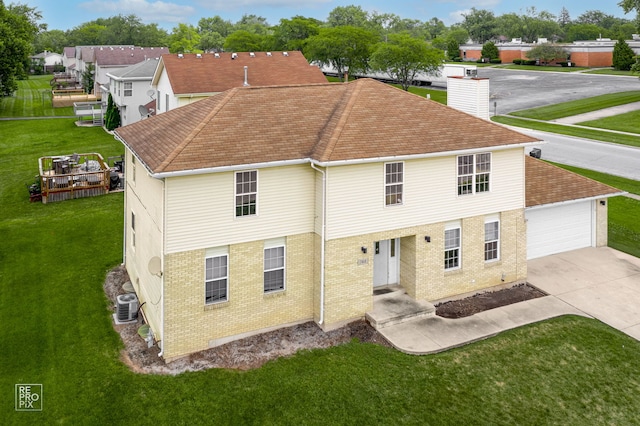 rear view of house featuring a yard, a garage, and central AC unit