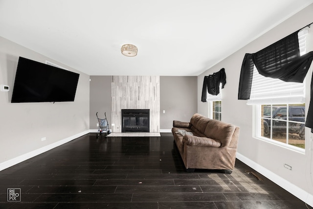 living room with a fireplace and dark wood-type flooring