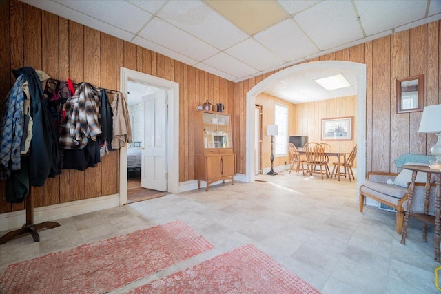 interior space with wood walls and a drop ceiling