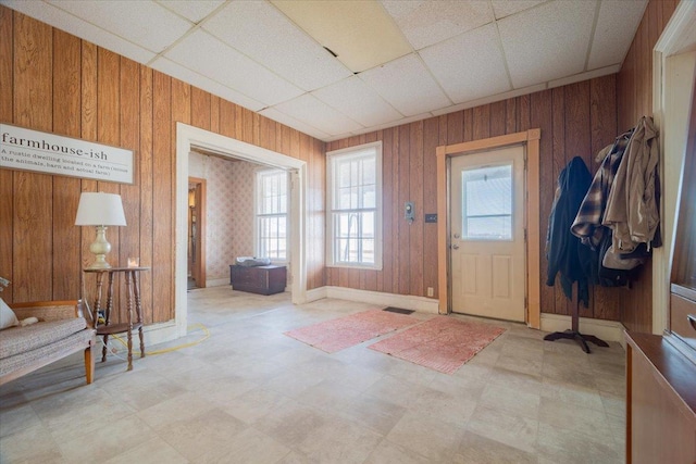 entryway with wood walls and a drop ceiling