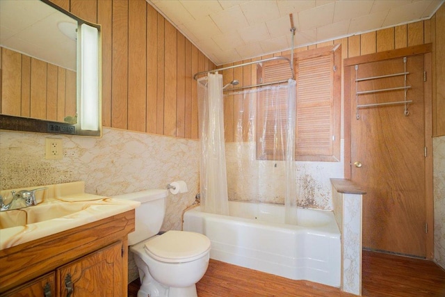 full bathroom with toilet, wood walls, shower / bath combo, and vanity