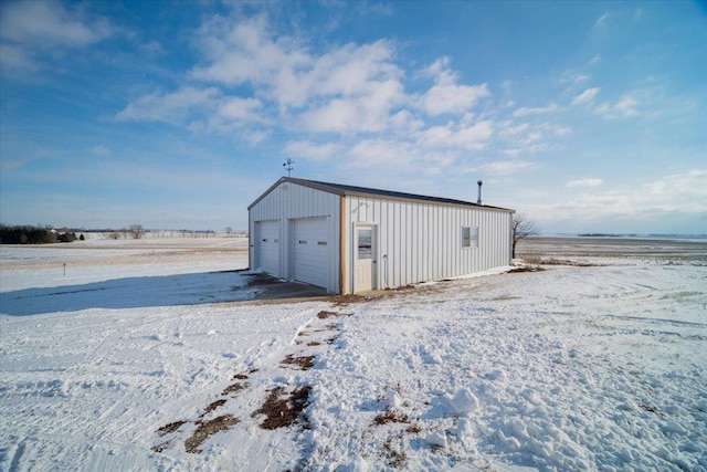 snow covered structure with a garage