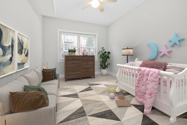 carpeted bedroom featuring ceiling fan and a nursery area