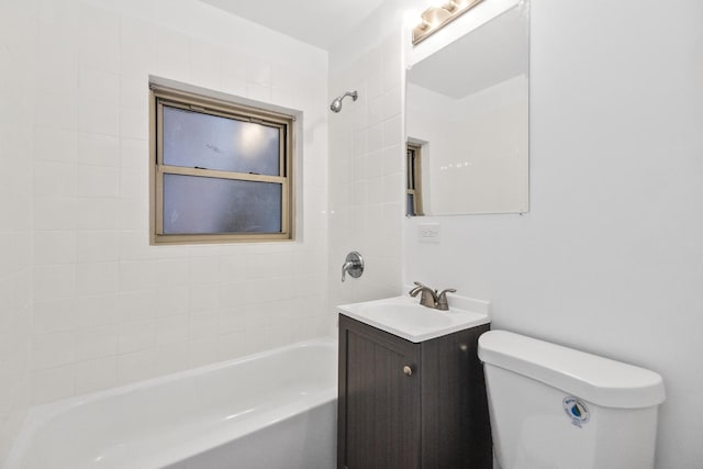 full bathroom with tiled shower / bath, vanity, and toilet