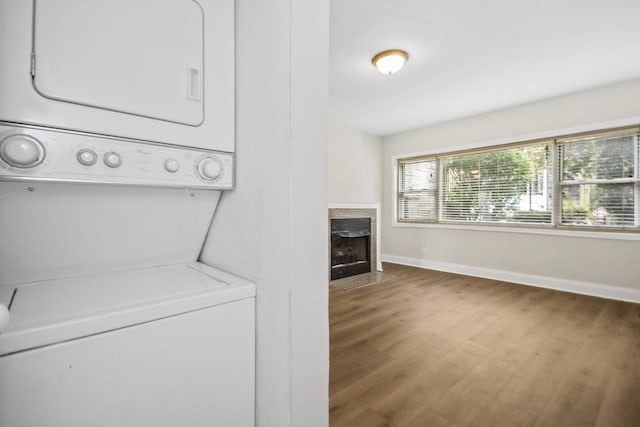 clothes washing area with stacked washer and dryer and dark hardwood / wood-style floors