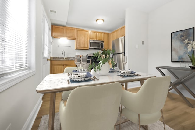 dining area with hardwood / wood-style flooring and sink