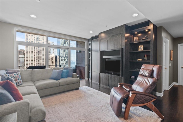 living room with built in shelves and hardwood / wood-style flooring