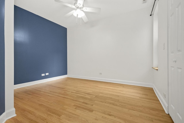 empty room with ceiling fan and light hardwood / wood-style floors