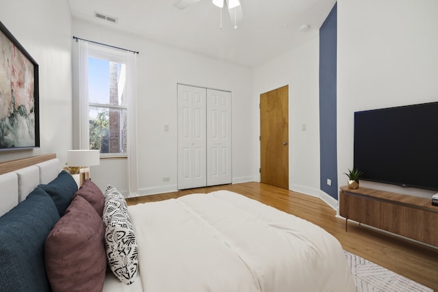 bedroom featuring ceiling fan, wood-type flooring, and a closet