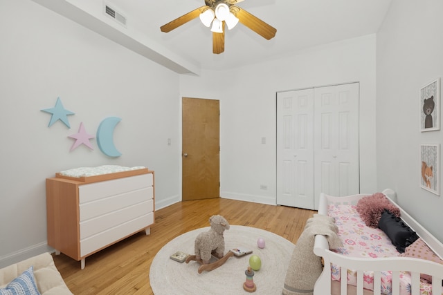 bedroom featuring ceiling fan, light wood-type flooring, and a closet