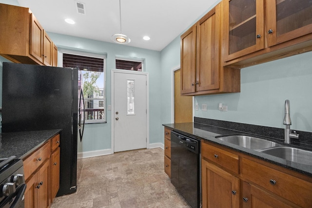 kitchen featuring dark stone counters, sink, and black appliances