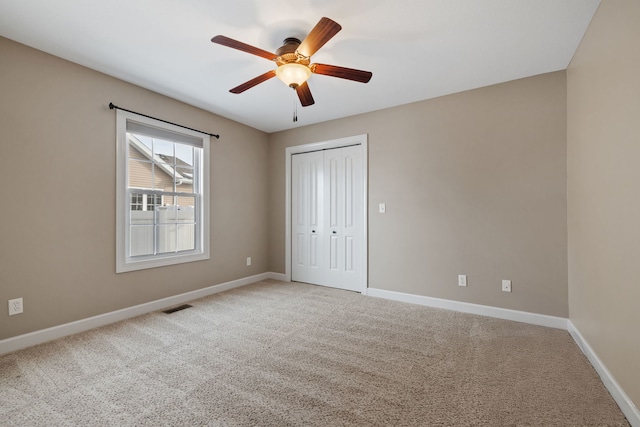 unfurnished bedroom featuring carpet, ceiling fan, and a closet