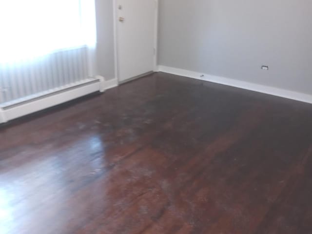 unfurnished room featuring a baseboard radiator