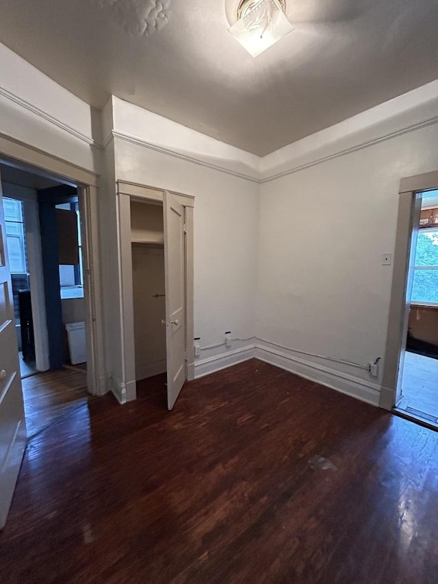 unfurnished bedroom featuring dark hardwood / wood-style flooring and a closet