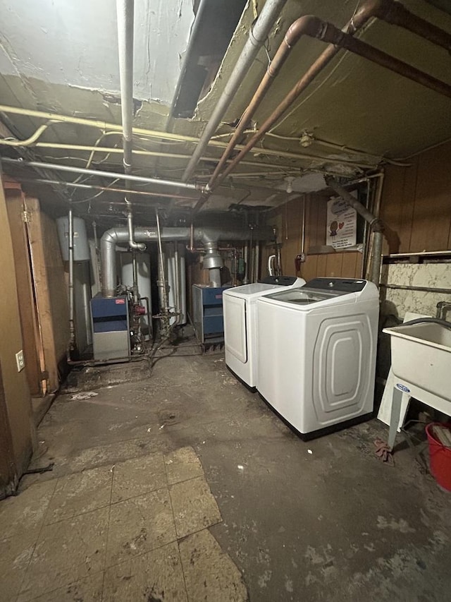 basement with water heater, sink, and washing machine and clothes dryer