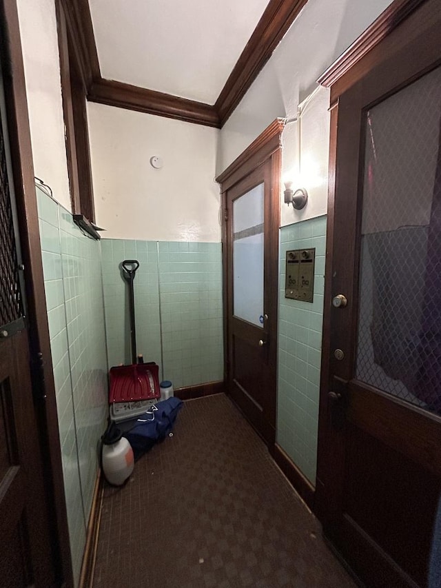 interior space with crown molding, carpet floors, and tile walls