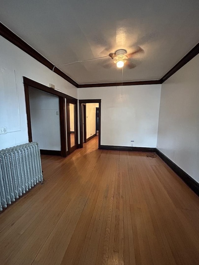 empty room with ceiling fan, ornamental molding, and hardwood / wood-style flooring