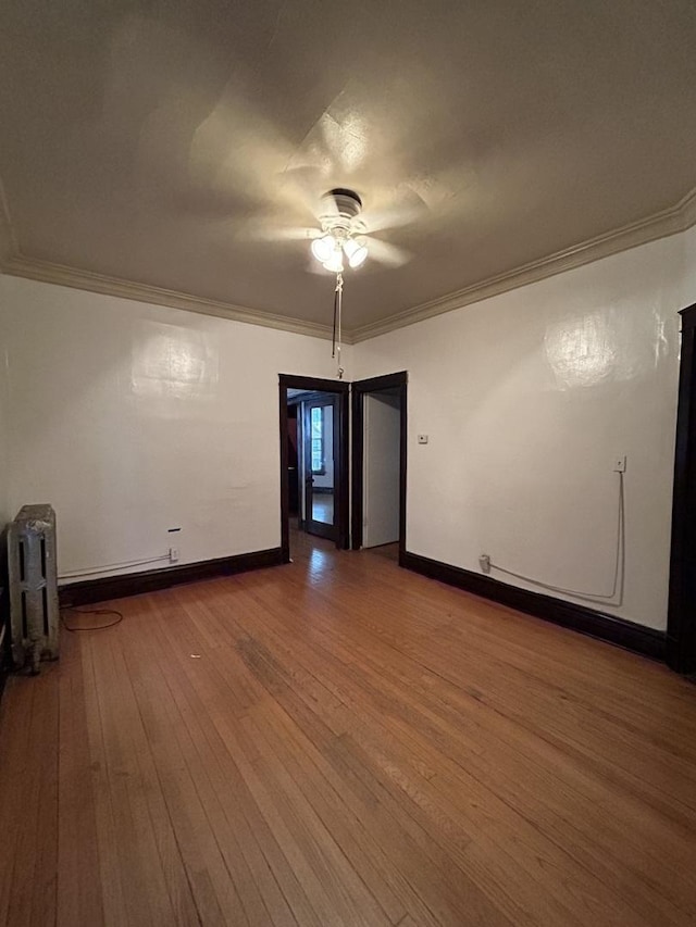 empty room with hardwood / wood-style flooring, ceiling fan, and crown molding