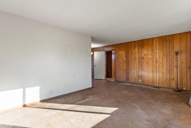 spare room featuring wood walls