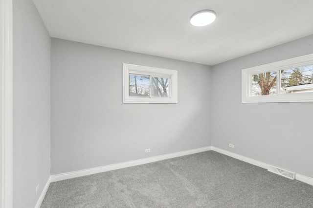 carpeted empty room featuring visible vents and baseboards