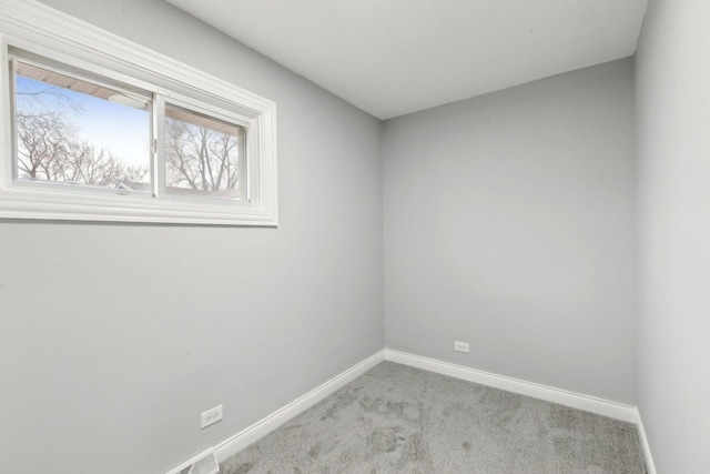 unfurnished room with light colored carpet and baseboards