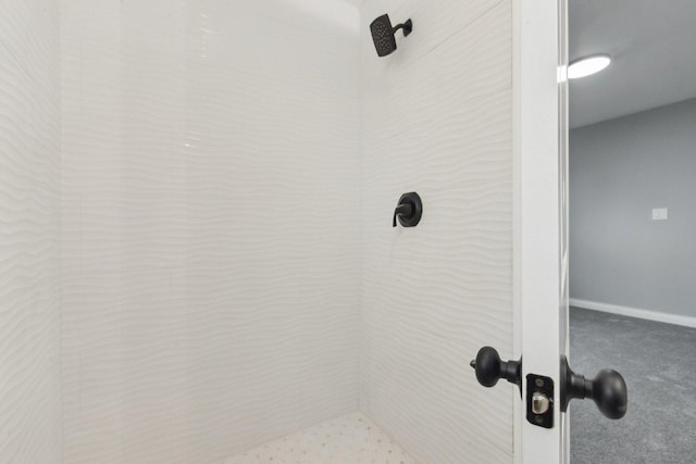 interior details featuring carpet, baseboards, and a tile shower