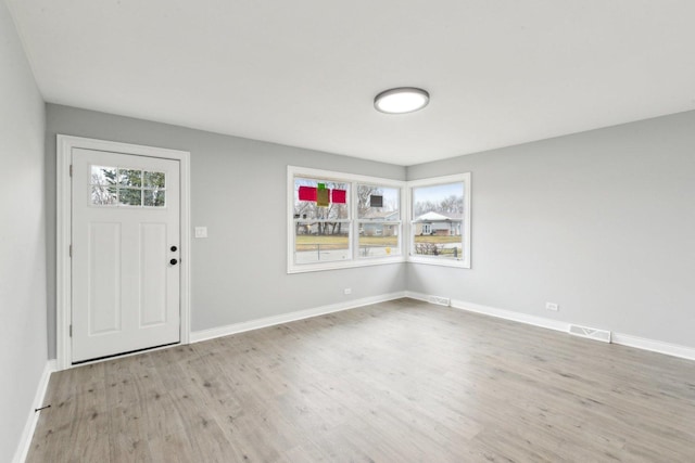 foyer entrance featuring wood finished floors, visible vents, and baseboards