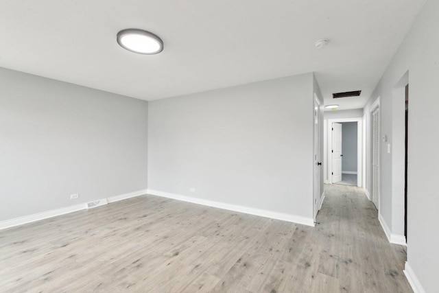 spare room with visible vents, light wood-style flooring, and baseboards