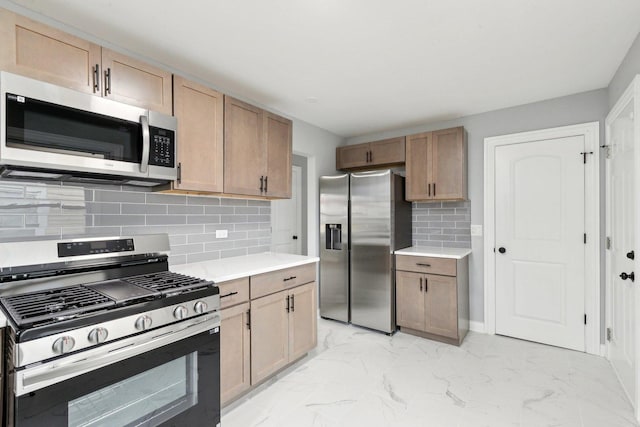 kitchen with stainless steel appliances, marble finish floor, light countertops, and decorative backsplash